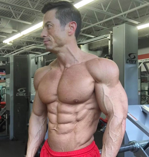 Alex Woodson in red shorts bulging muscles, vascular arms 