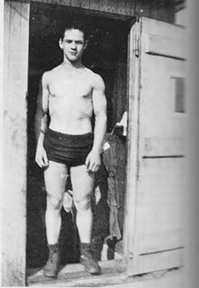 A young John Grimek standing in a doorway 