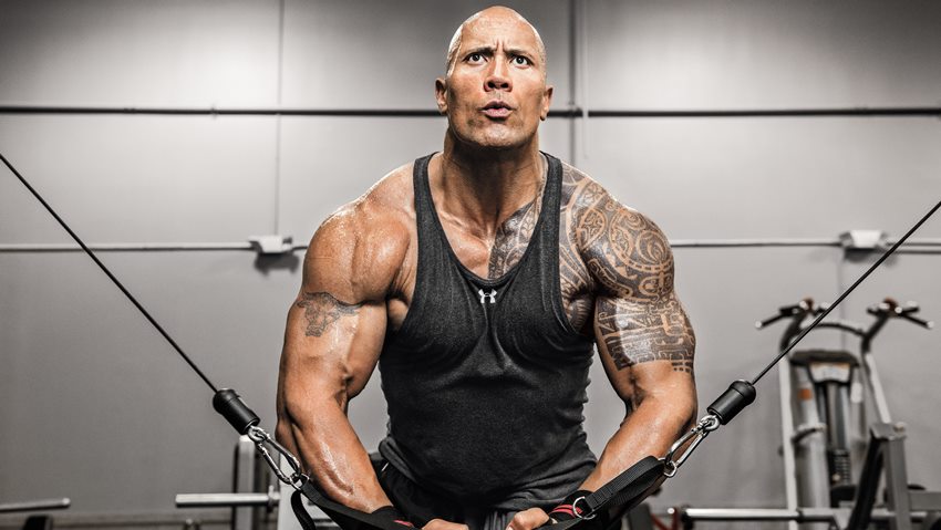 Dwayne Johnson The Rock doing cable crossovers for chets in the gym