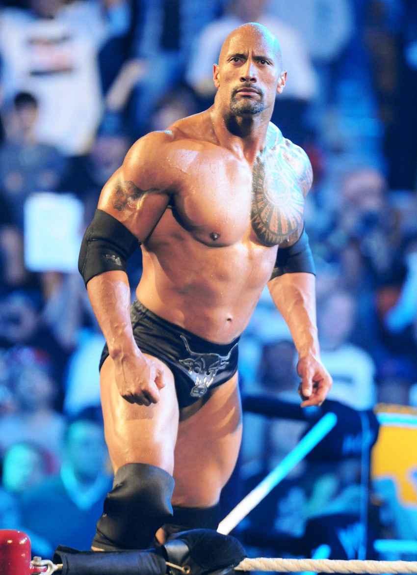 Dwayne Johnson The Rock standing on top of a ring in a huge stadium full of crowd