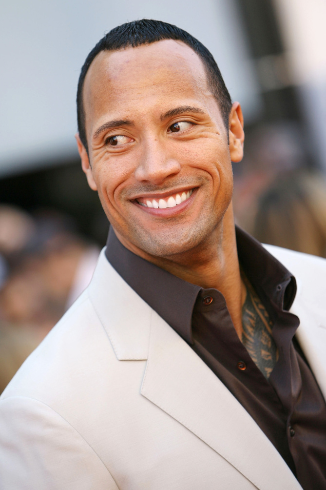 Dwayne Johnson The Rock in a white suit smiling