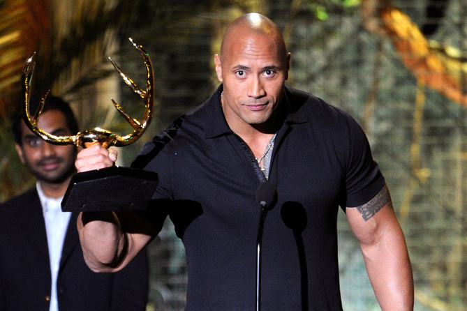 Dwayne Johnson The Rock holding an award in his hands