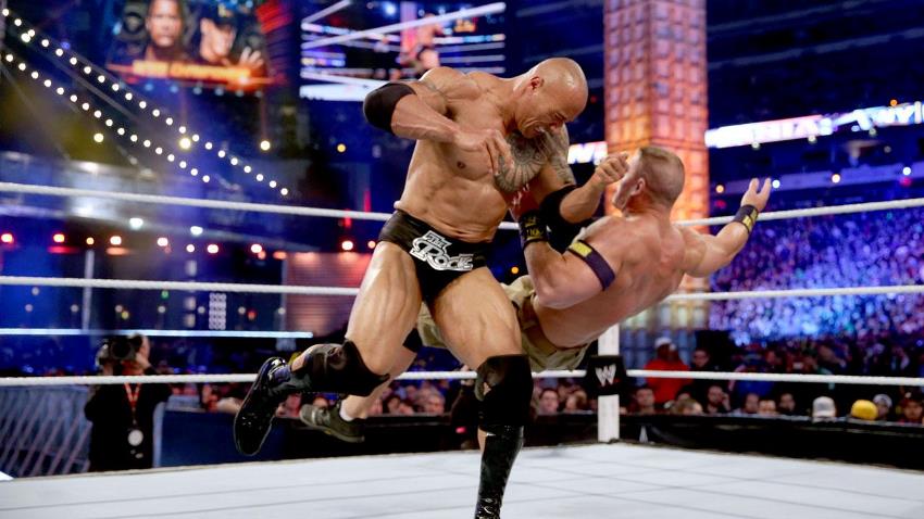 Dwayne Johnson The Rock performing a finishing move on John Cena