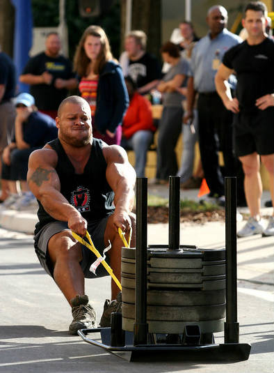 elliott hulse drags a weighted trolley in a strongman competition