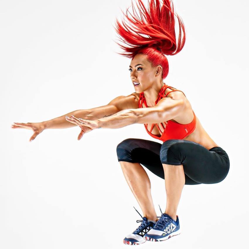 Hannah Eden jumping during a photoshoot, with her arms straight forward