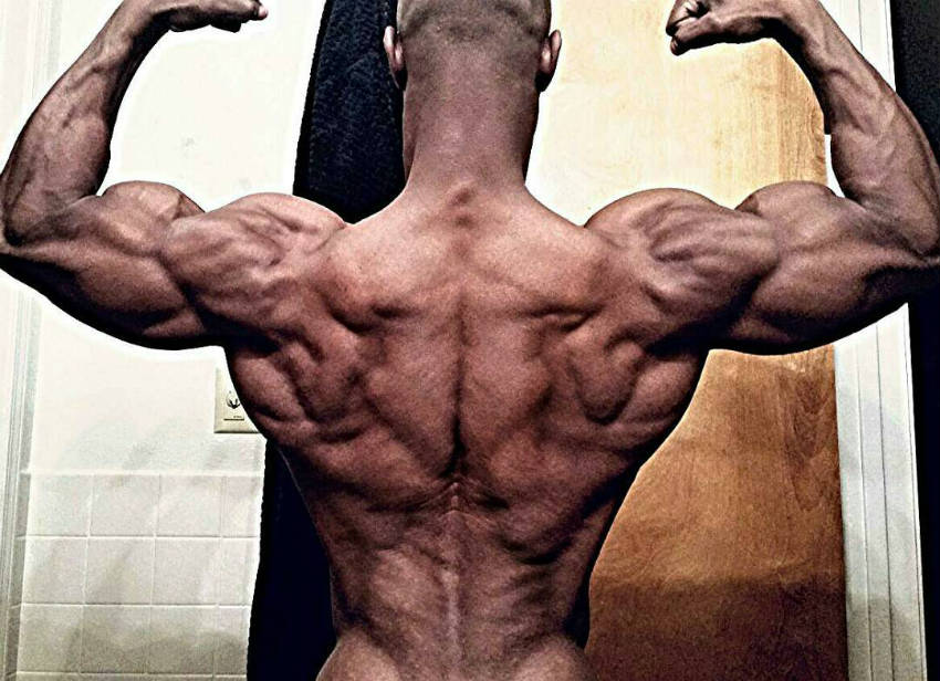 robert niter flexes his back and arm muscles