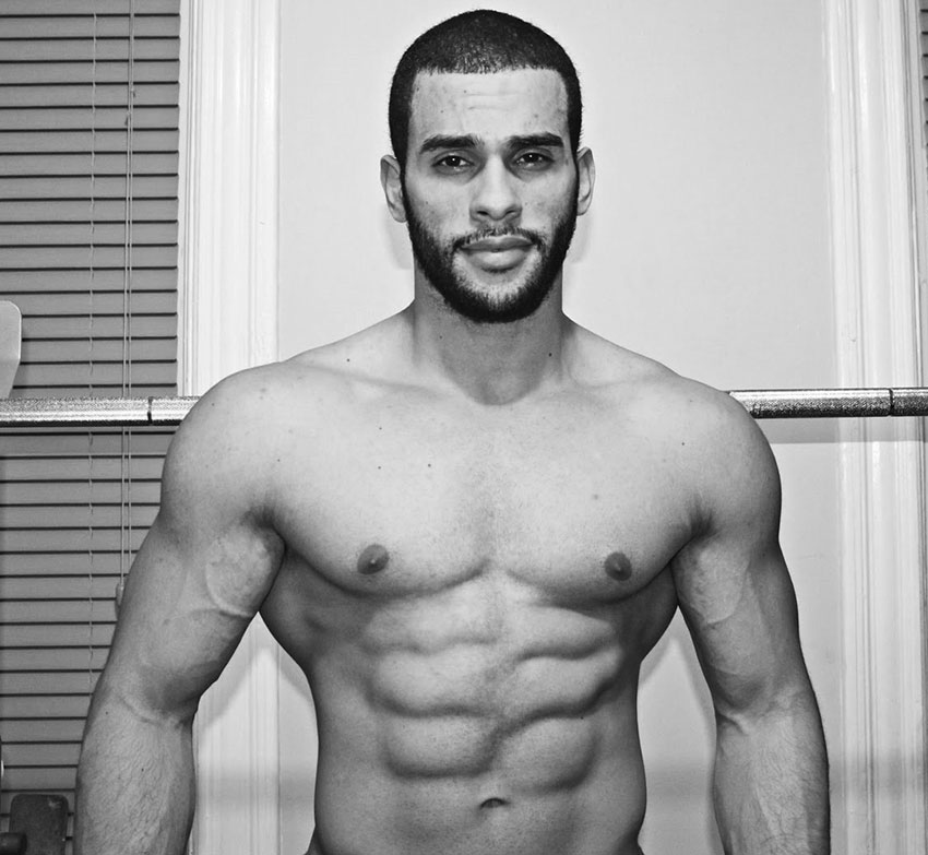 Alex Los Angeles posing in his house with his shirt off showing his ripped abs