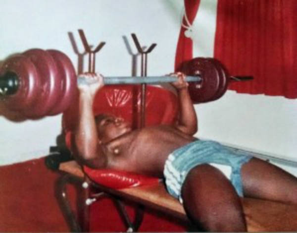 Charles Dixong completing a bench press on his first weights set as a boy