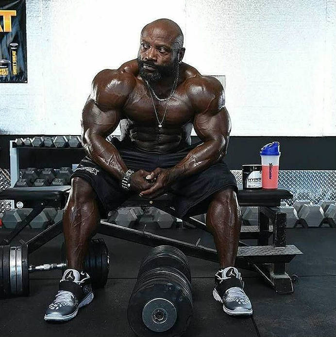 Charles Dixon sitting in front of a dumbbell