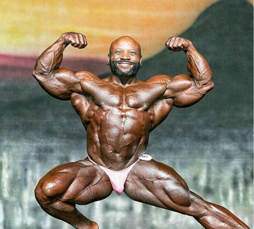 Charles Dixon posing at a competition in a stretched stance