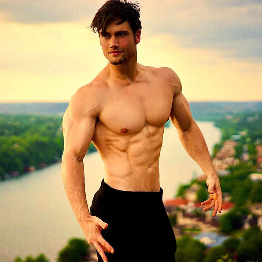 Connor Murphy standing outside shirtless flexing his abs and chest 