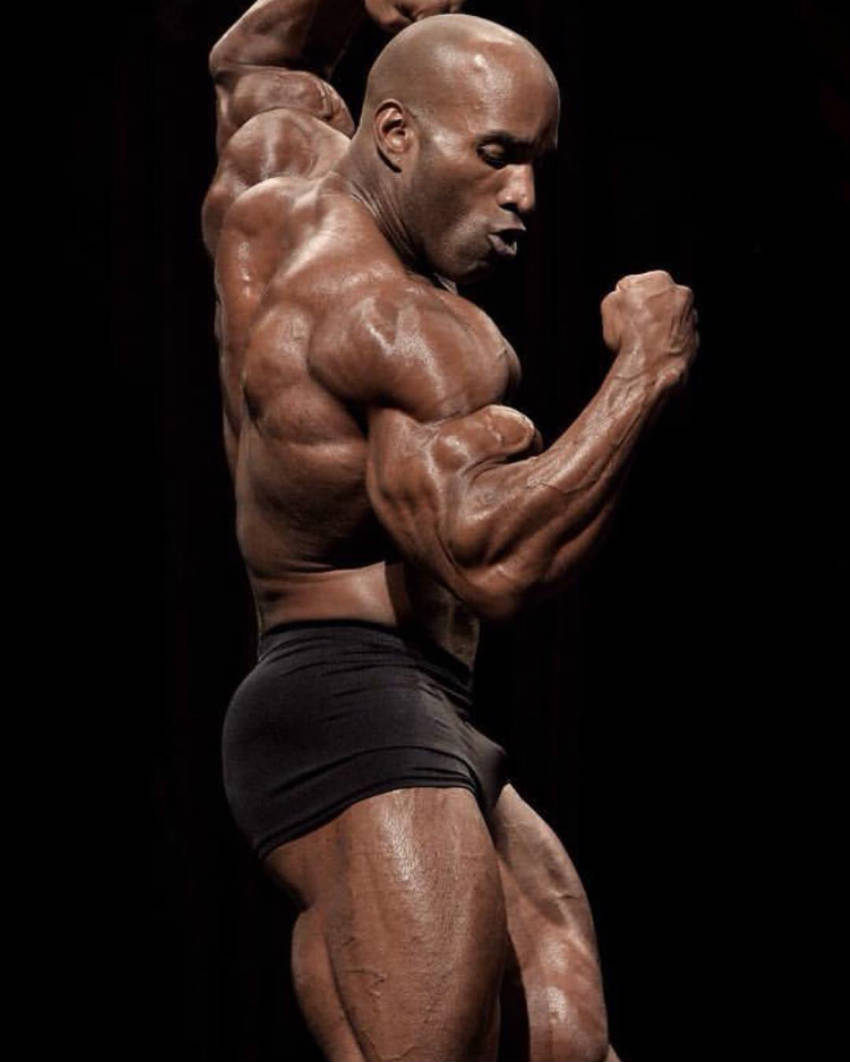 Darrem Charles tensing his bicep before competition