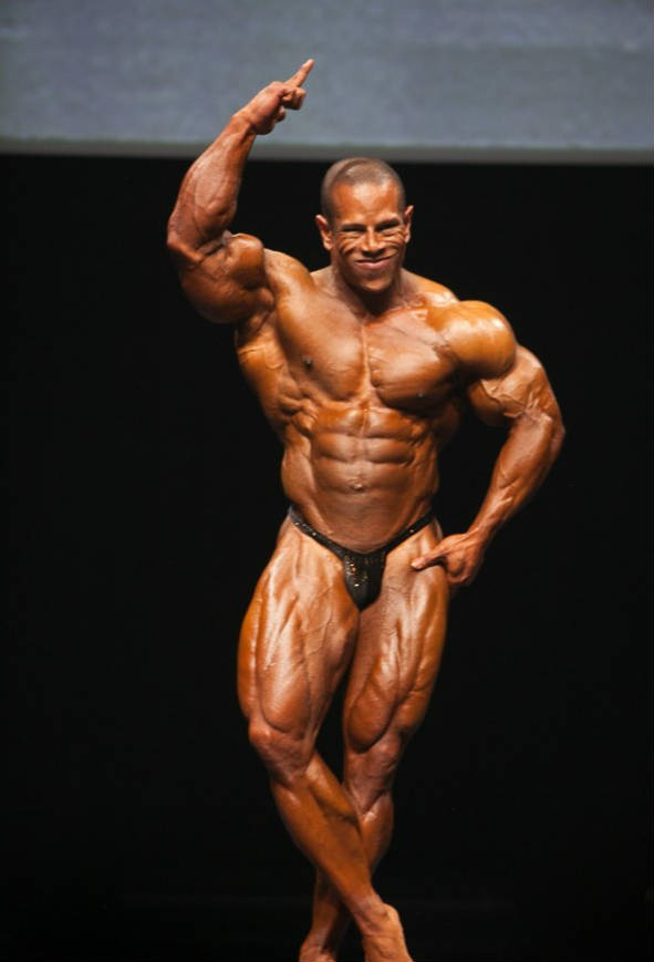 David Henry posing at a competition with his finger in the air 