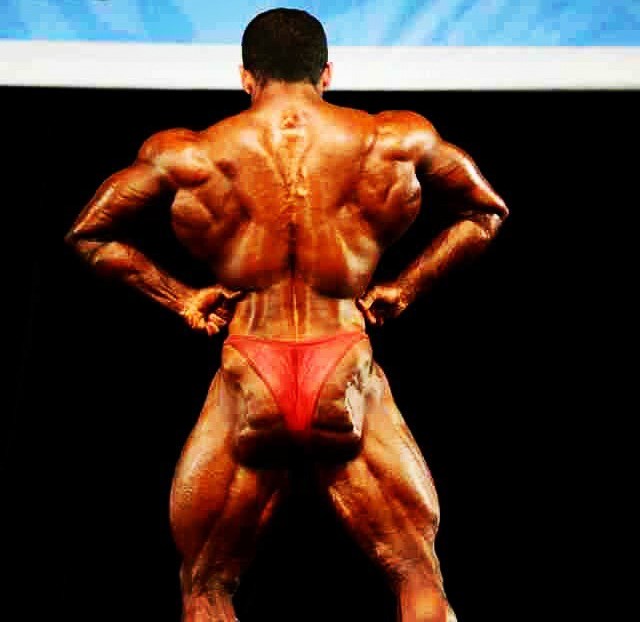 Hadi Choopan in a back lat spread pose on the stage