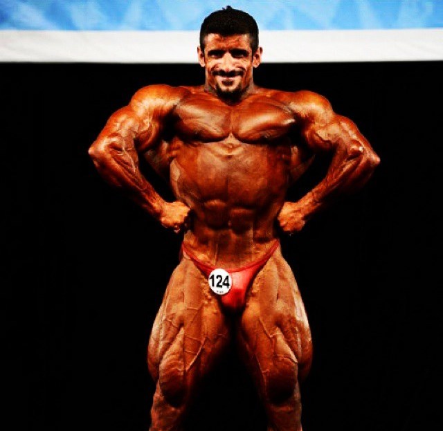 Hadi Choopan in a front lat spread pose on the stage