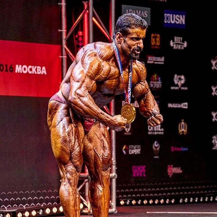 Hadi Choopan in a most muscular pose on the stage, as he shows his medal-winning physique to the audience