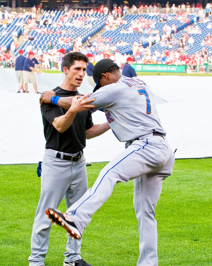 Jeff Cavaliere working as the head physical therapist for New York Mets with Jose Reyes on the field 