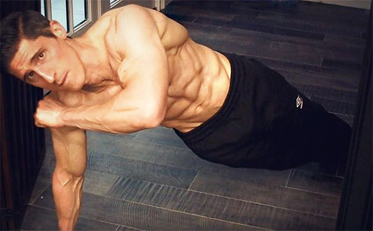 Jeff Cavaliere performing abs exercises while talking to the camera as a personal trainer in his personal gym.