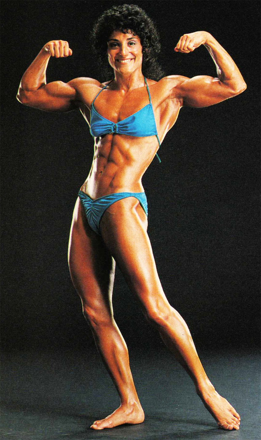 Profile picture of Laura Combes posing in her stage bikini, flexing her biceps and displaying her trademark figure.