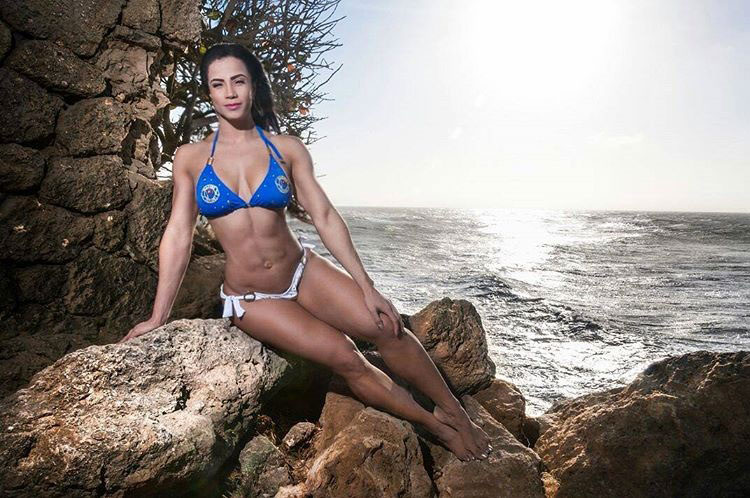 Luz Elena Echeverria Molina sitting on a rock next to the ocean wearing a bikini looking strong and healthy 