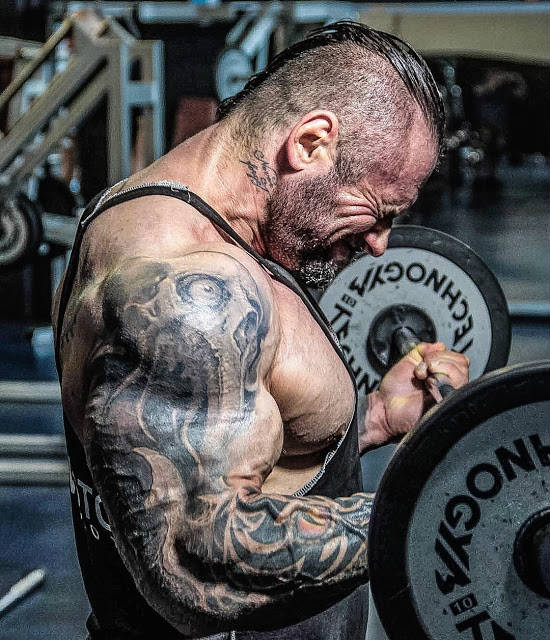 Miha Zupan completing a bicep barbell curl