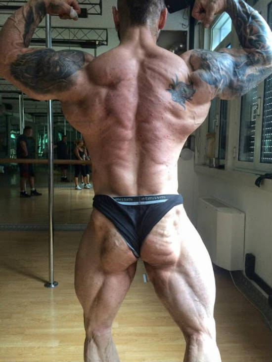 Miha Zupan flexing his back muscles in the gym