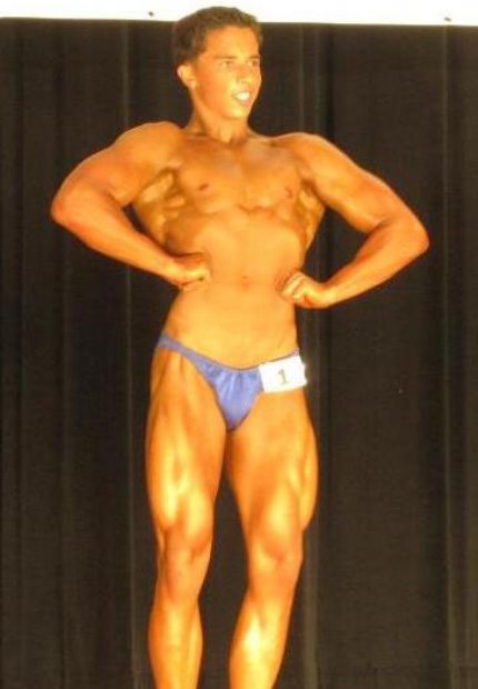 Nick Wright in a front lat spread pose on the stage