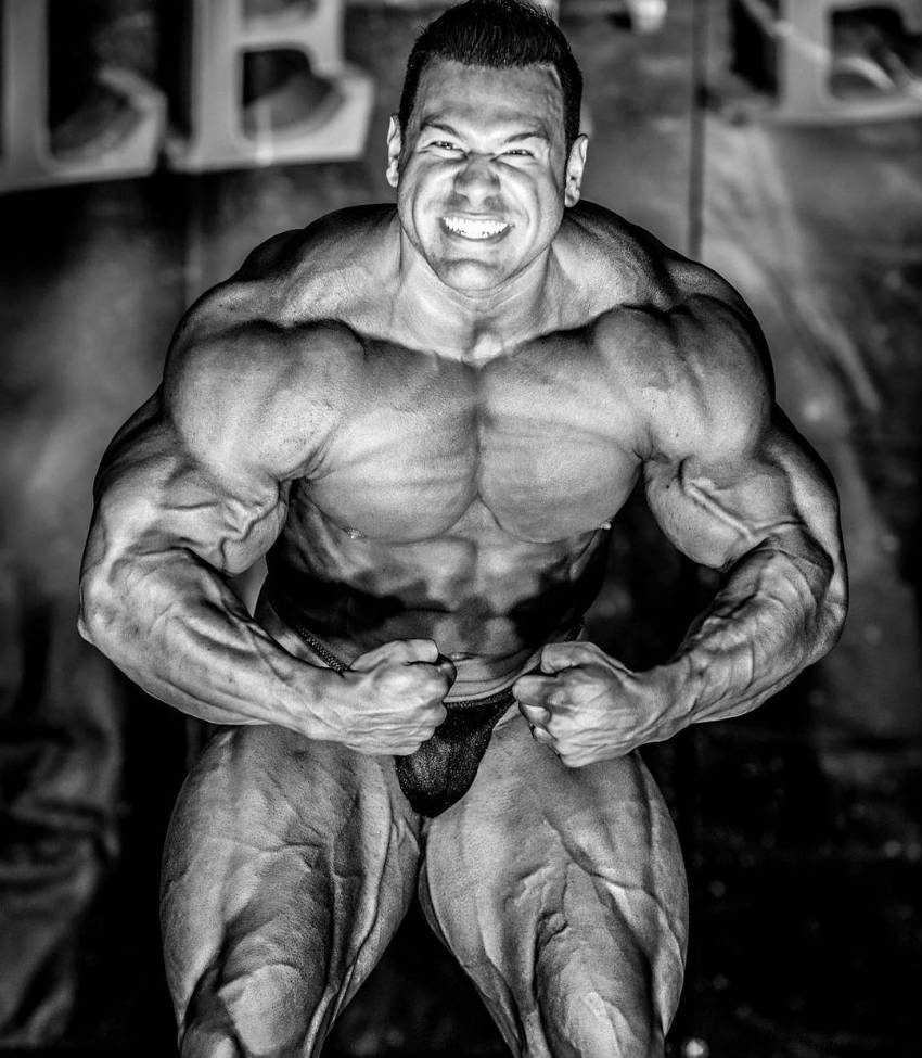 Steve Kuclo flexing at a competition (black and white)