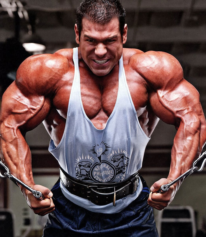 Steve Kuclo flexing his biceps and chest while performing cable flys
