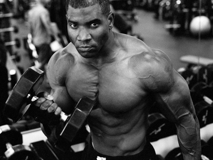 Xavisus lifting completing dumbbell curls in the gym  