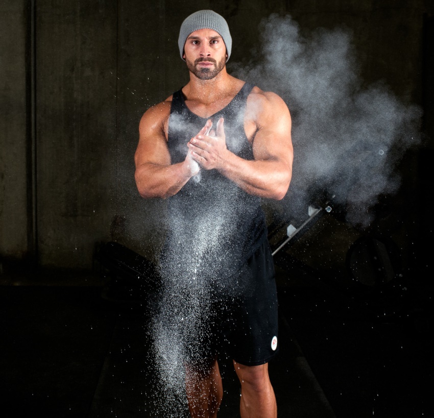 Bradley Martyn clapping his hands covered in chalk dust, spreading the dust everywhere in the air as he claps