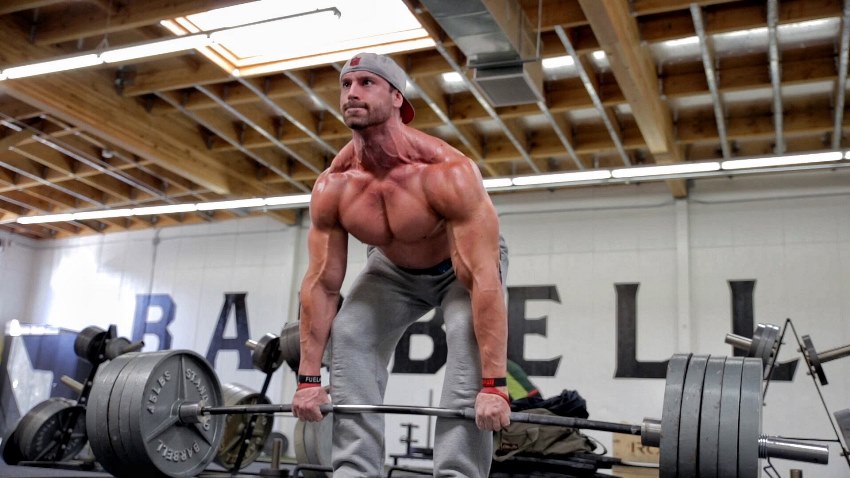 Bradley Martyn macht schwere Kreuzheben in der Turnhalle, seine Adern platzen am ganzen Körper als Ergebnis der anstrengenden Aktivität