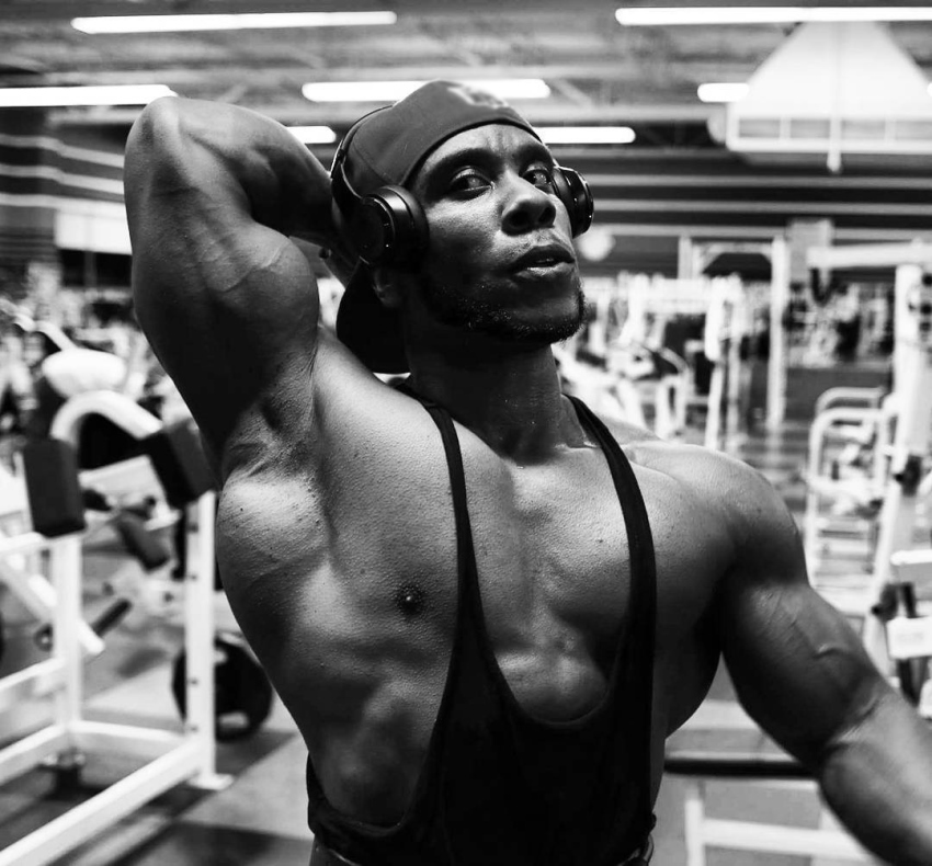 Chris Jones profile picture, where he's posing in the gym, showing his arms, lats, serratus, and chest