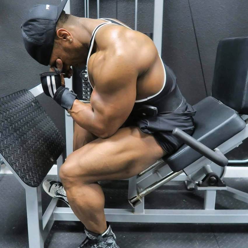 Chris Jones sitting on a leg press machine with a painful expression on his face