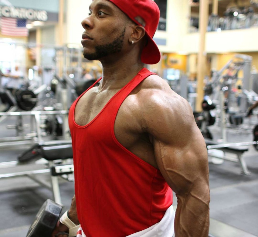 Chris Jones with dumbbells in his hands, showing his vascular and ripped arms