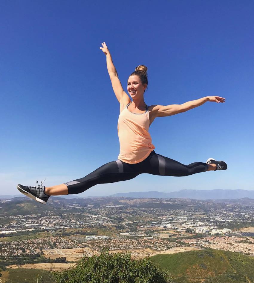 Jessie Delgado jumping high in the air with a big smile on her face