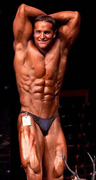 Layne Norton showing his abs to the audience in front of the bodybuilding stage