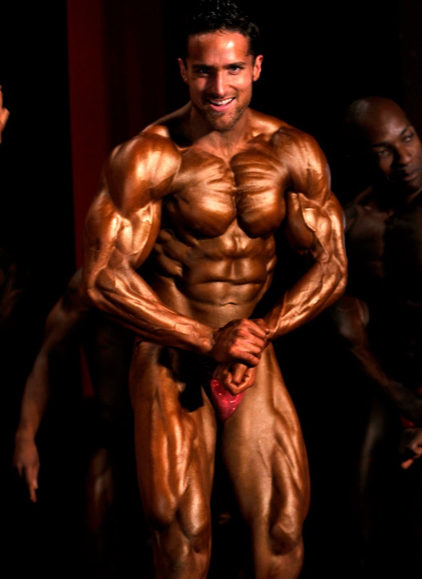 Layne Norton tanned up on a stage, posing alongside other competitors