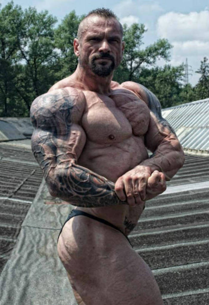 Miha Zupan tensing his bicep while standing outdoors