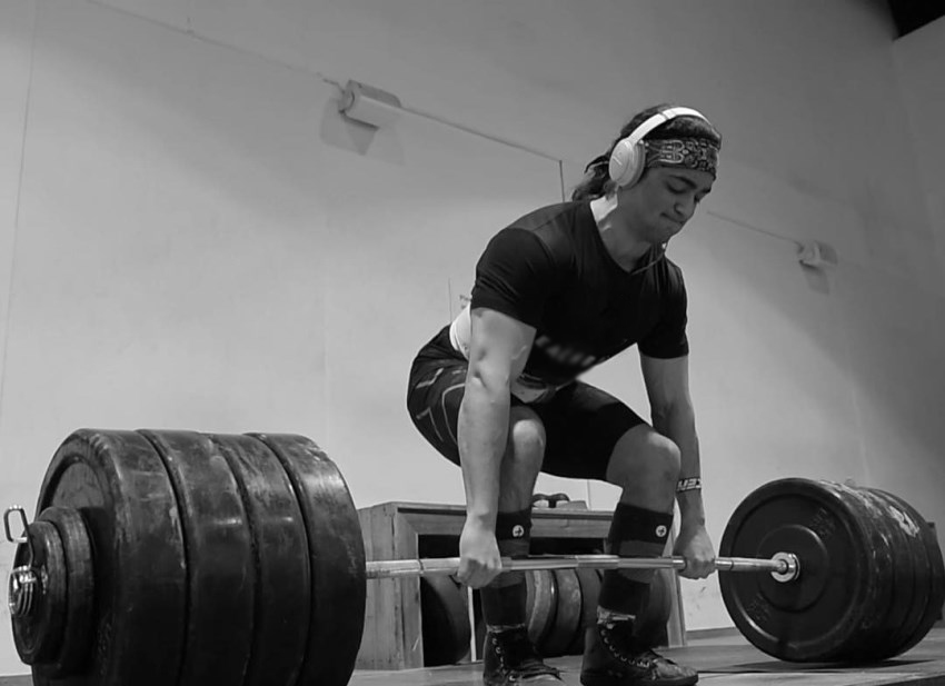 Omar Isuf doing deadlifts with headphones