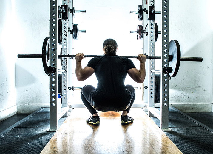 Back shot of Omar Isuf doing squats