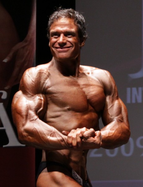 Rob Deluca in a side chest pose while on a stage