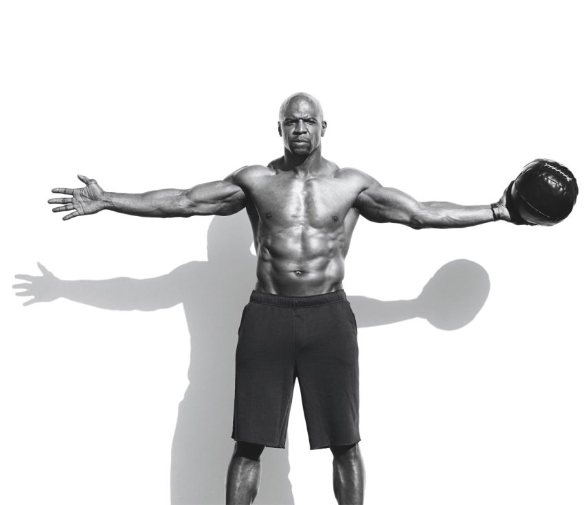 Terry Crews having his hands widespread while looking directly in the camera, showing his ripped physique