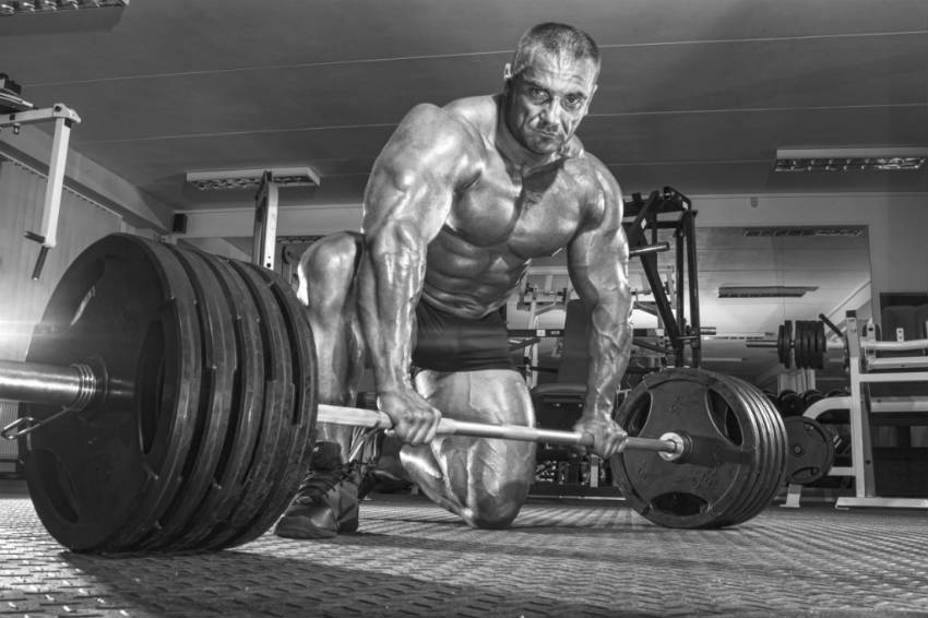 tomas kaspar kneeling in front of barbell