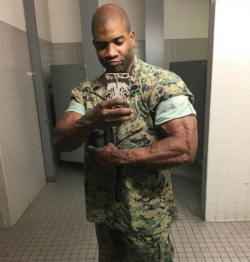 Xavisus Gayden wearing his marine uniform posing and flexing his bicep