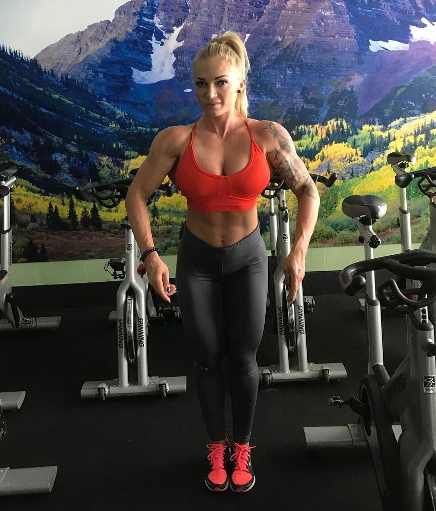 Alina Pettke spreading her lats in the gym, showing her developed and lean muscles