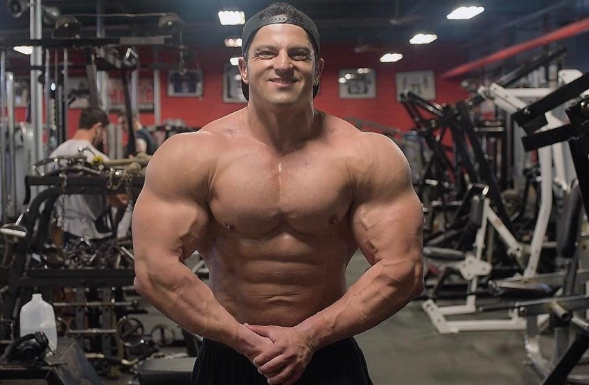 Arash Rahbar in the offseason, posing in the gym, showing his massive, yet aesthetic physique