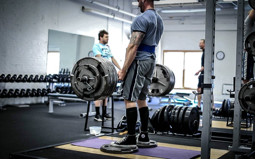 Brandon Campbell completing a deadlift and showing his large trices