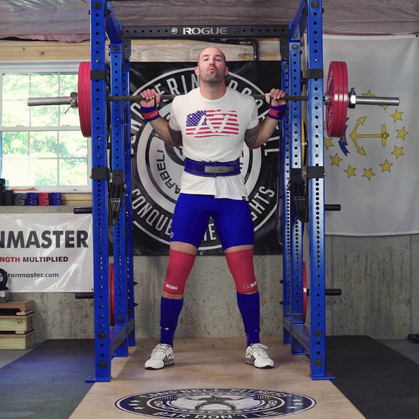 Brandon Campbell standing in the squat rackm showing off his strong legs