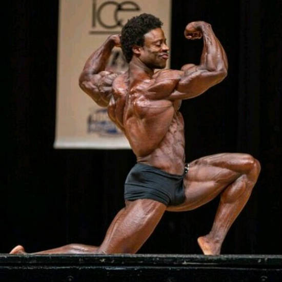 Breon Ansley posing with confidence at the New York Pro, tensing his large biceps